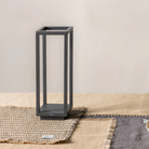The dark gray Home Cordless Lamp from Zafferano on a dining room table on top of a placemat.