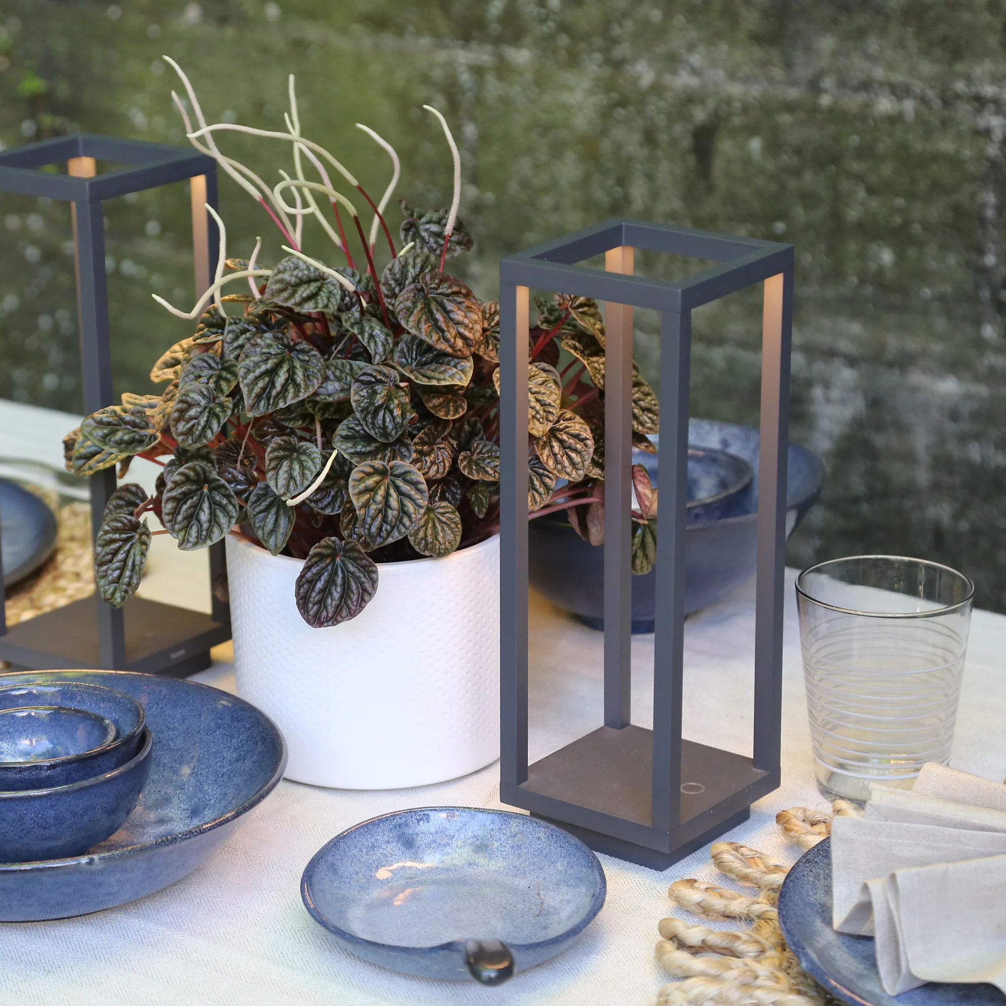 The dark gray Home Cordless Lamp from Zafferano in a restaurant on top of a dining table.