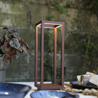 The rust Home Cordless Lamp from Zafferano in a cafe on a table.