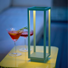 The sage Home Cordless Lamp from Zafferano in a living area on top of an end table.