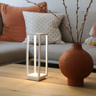 The white Home Cordless Lamp from Zafferano in a living room on top of a coffee table.