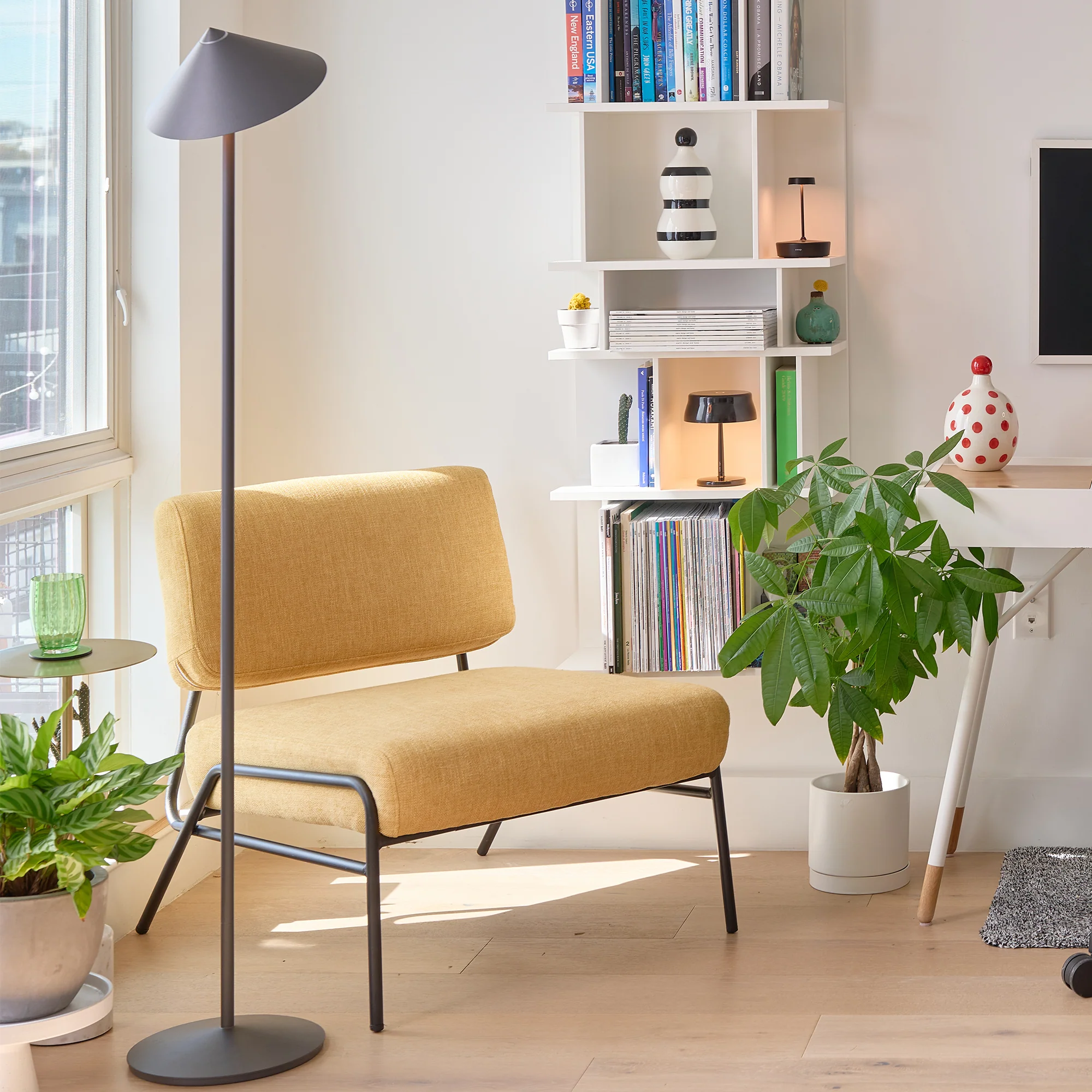 The titanium Pina XXL Cordless Floor Lamp from Zafferano in a living room beside a chair.