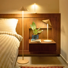 The white Pina XXL Cordless Floor Lamp from Zafferano in a bedroom with other portable lights. all-groups