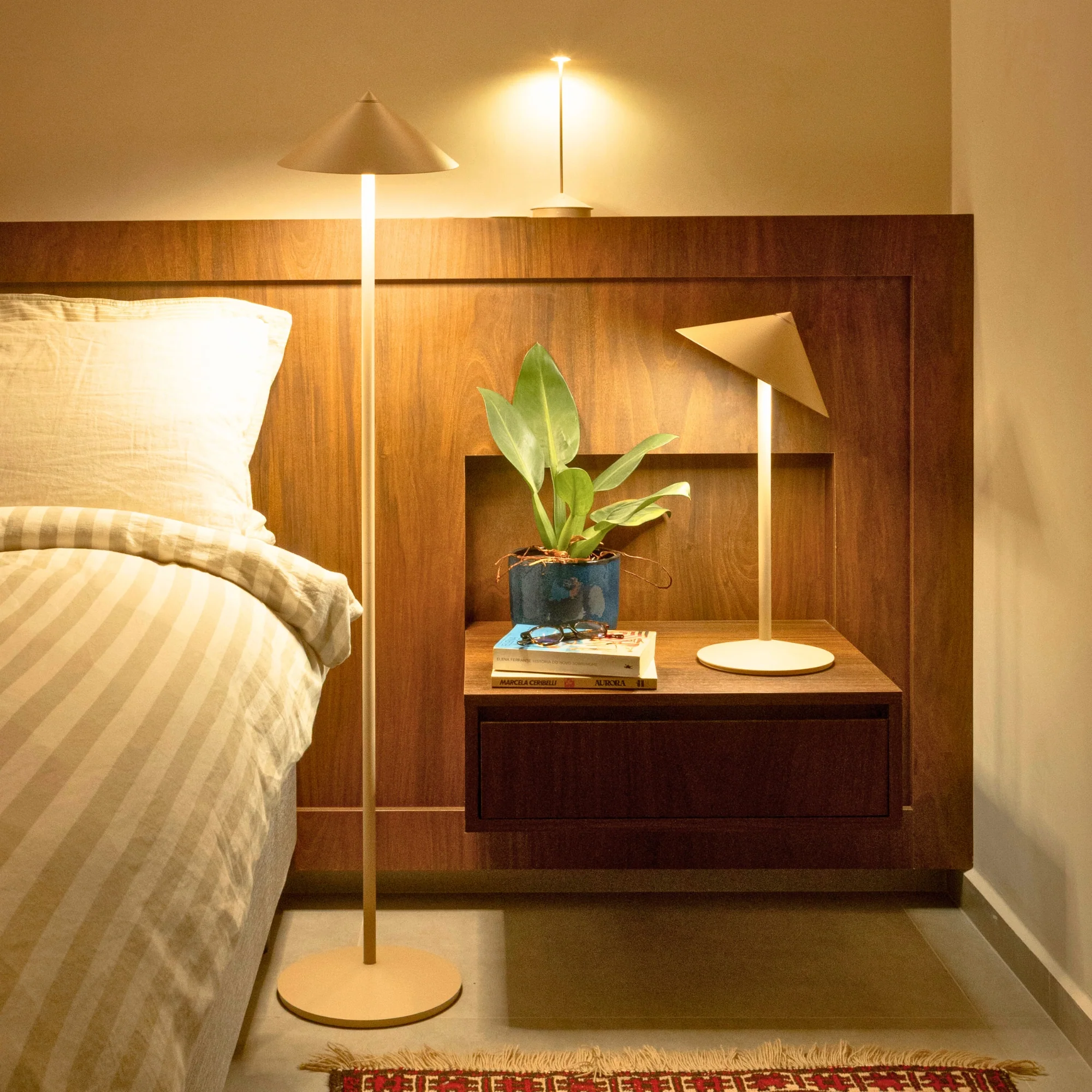 The white Pina XXL Cordless Floor Lamp from Zafferano in a bedroom with other portable lights. all-groups