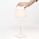 The white Poldina Classic Cordless Lamp from Zafferano in a studio showing the removable LED module.