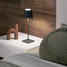 The dark gray Poldina Pro from Zafferano in a guest bedroom on top of a bedside table.
