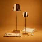 The glossy gold Poldina Pro from Zafferano in a living room with various gold decor.