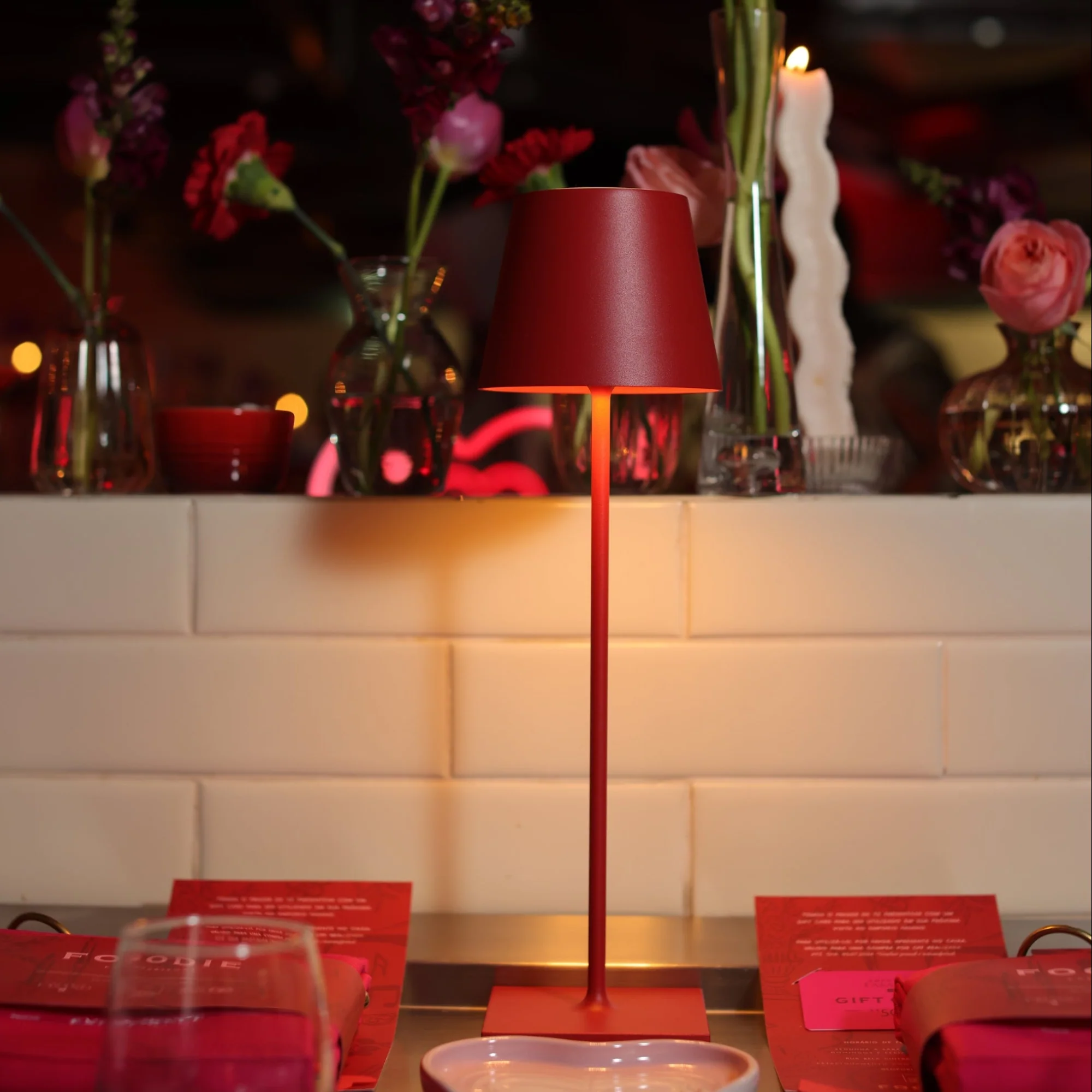 The red Poldina Pro from Zafferano in a living room on top of a table with various decor.