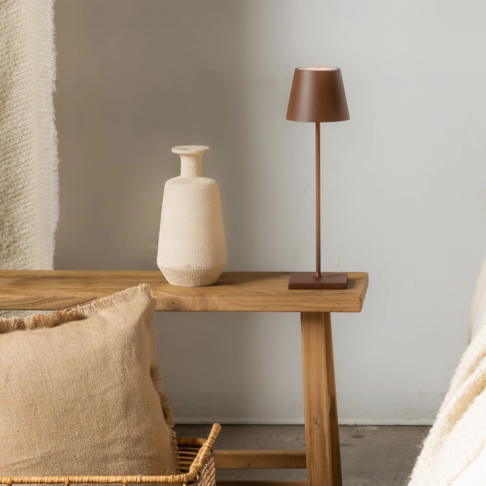 The rust Poldina Pro from Zafferano in a lounge on top of a bench.