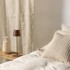 The rust Poldina Pro from Zafferano in a primary bedroom on a bench beside the bed.