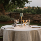 The sage Poldina Pro from Zafferano in a garden with a bottle of wine and several glasses.