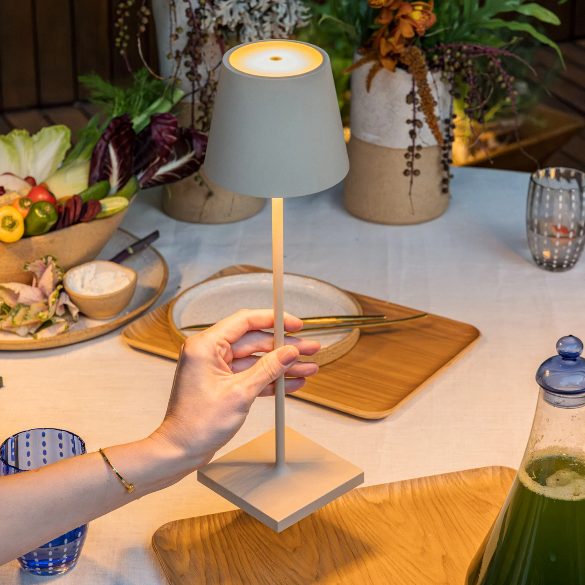 The sand Poldina Pro from Zafferano on a dining table with various snacks, flowers and drinks.