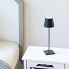The steel blue Poldina Pro from Zafferano in a primary bedroom beside a bed.