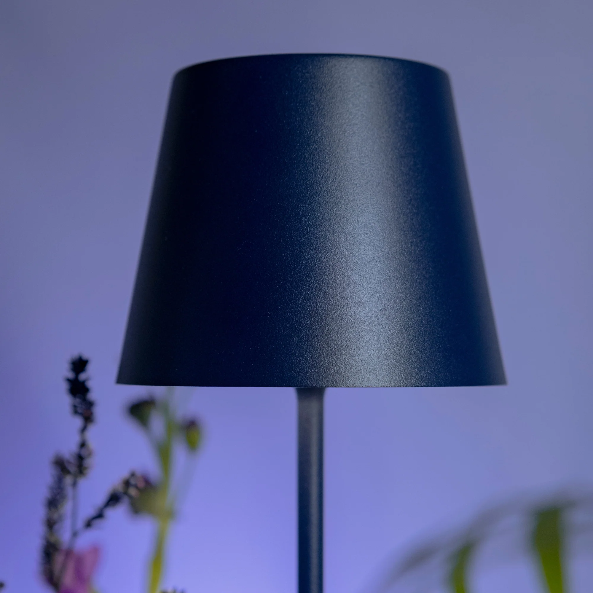 The steel blue Poldina Pro from Zafferano in a tv room, with the television lighting up the back wall.