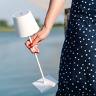 The white Poldina Pro from Zafferano handheld by a woman in a garden.