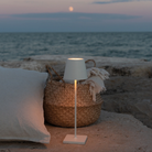 The white Poldina Pro from Zafferano in an outdoor living space overlooking an ocean.