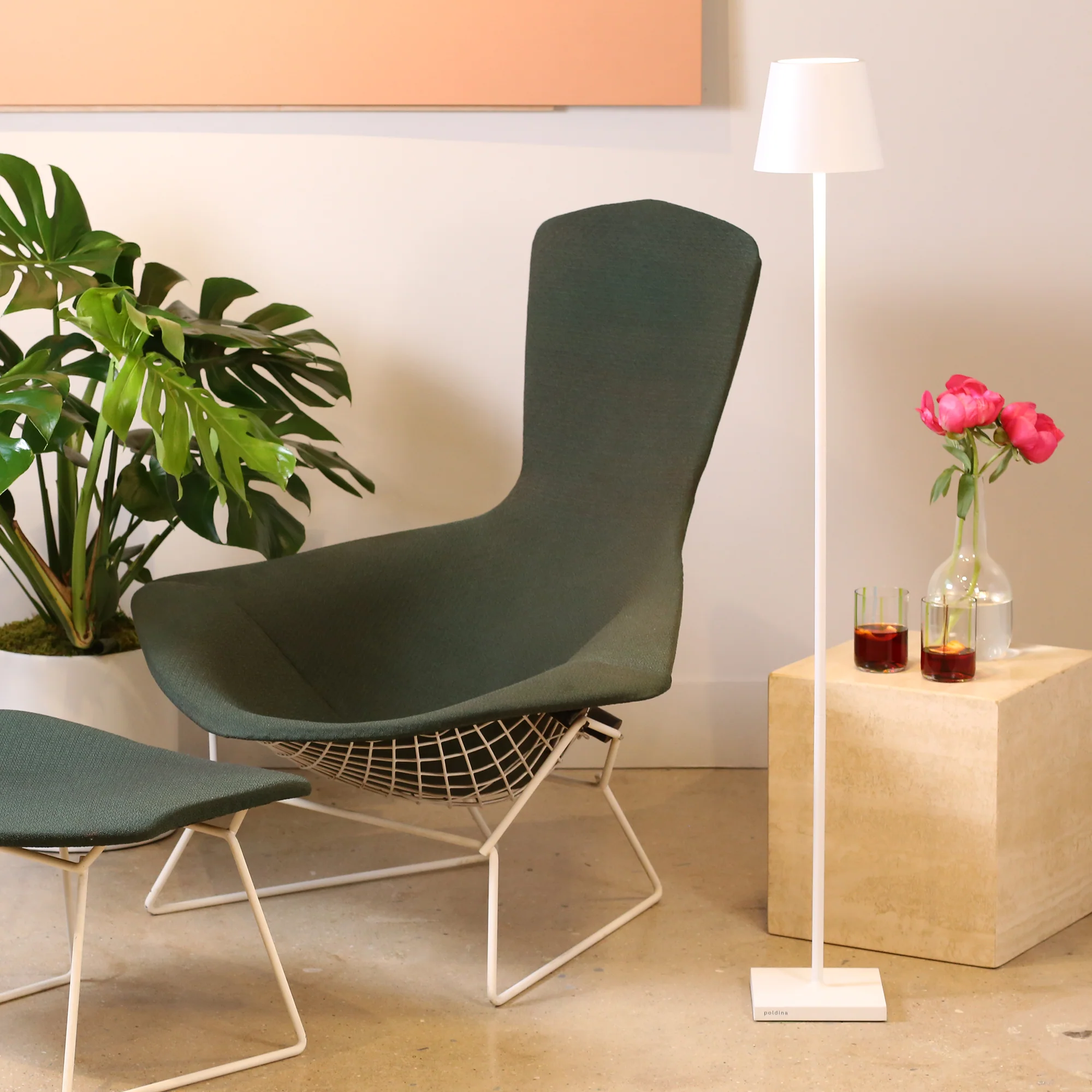 The white Poldina Pro L Floor Lamp from Zafferano in a family area next to a seat and a side table.