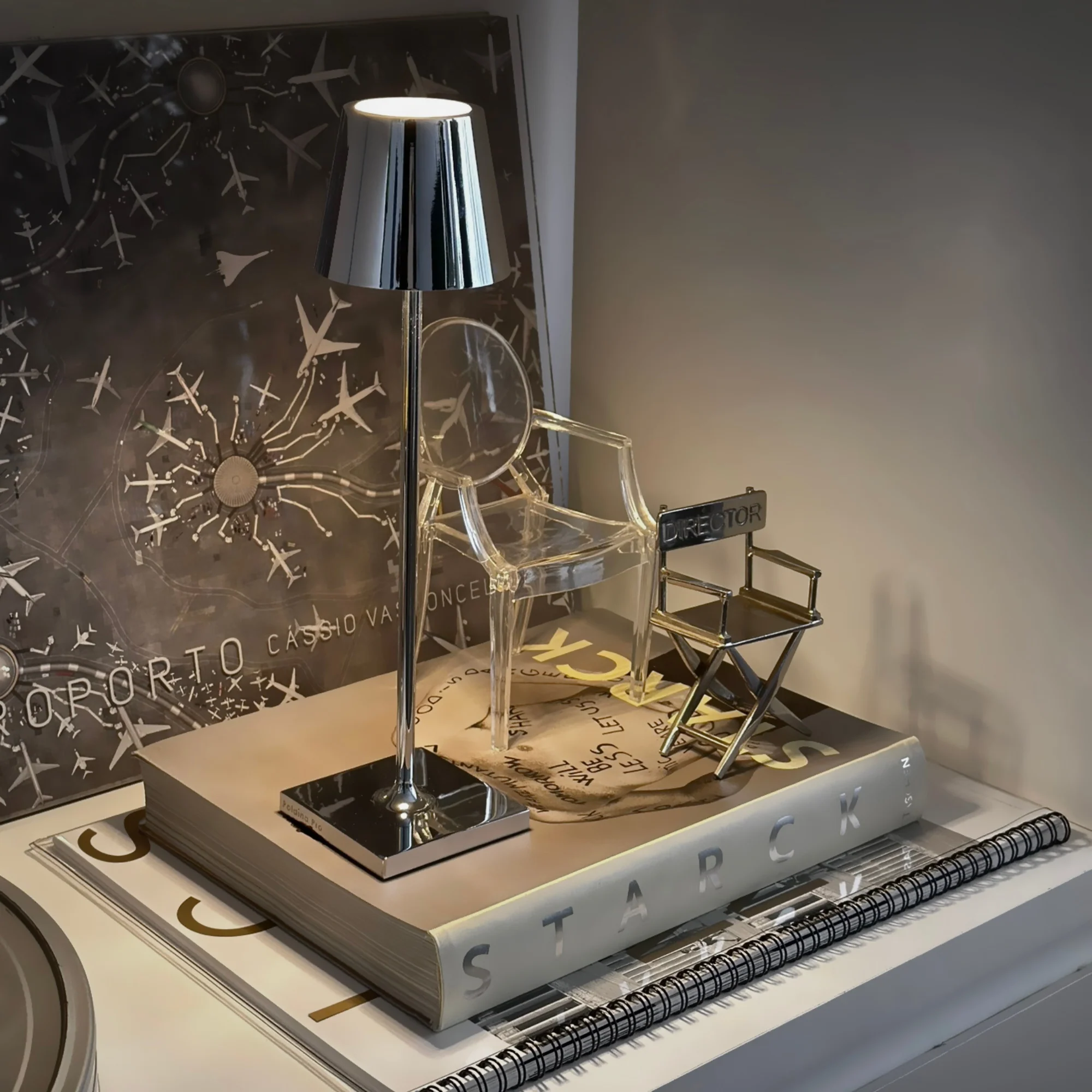 The glossy chrome Poldina Pro Micro Cordless Lamp from Zafferano in a primary bedroom on a bedside table.