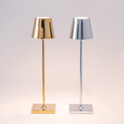 The glossy chrome Poldina Pro Micro Cordless Lamp from Zafferano next to the glossy gold Poldina Pro Micro Portable Lamp in a studio.