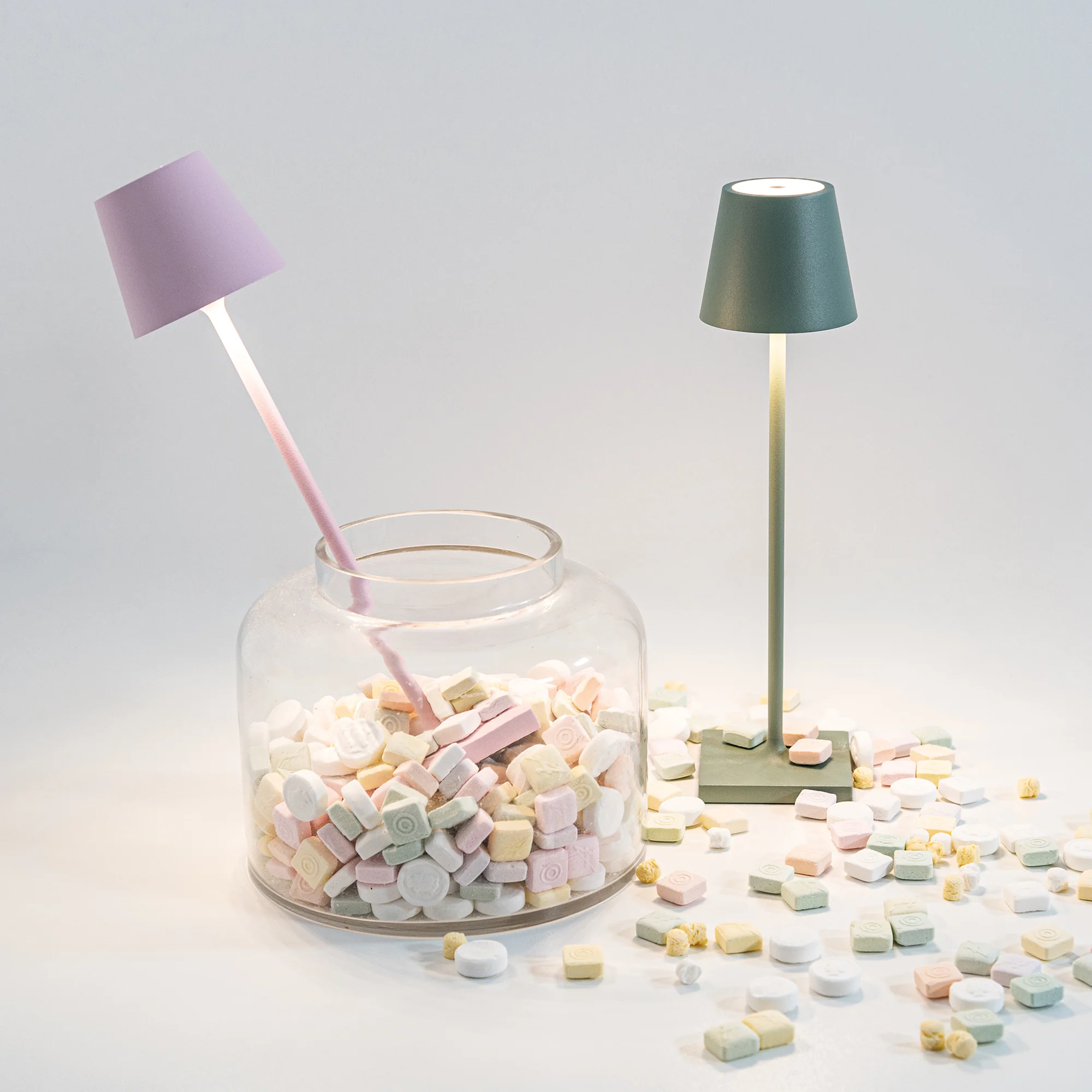 The pink Poldina Pro Micro Cordless Lamp from Zafferano in a kitchen studio in a candy jar.