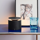 The dark grey PushUp Pro Cordless Lamp from Zafferano in a living room beside a family painting on a shelf.