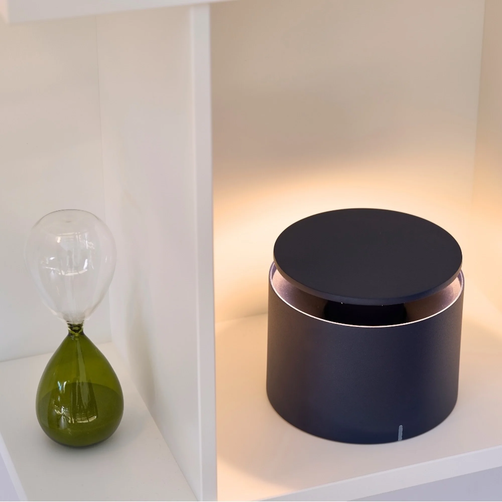 The steel blue PushUp Pro Cordless Lamp from Zafferano in a home office on a bookshelf.