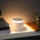 The white PushUp Pro Cordless Lamp from Zafferano in a bedroom on top of a table.
