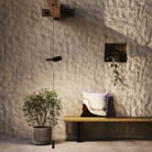 The black Super O Suspended Cordless Floor Lamp from Zafferano in a living space beside a bench suspended from a beam. all-groups