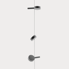 The black Super O Suspended Cordless Floor Lamp from Zafferano with 3 lights in a studio.
