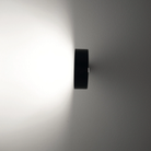 The black Super O Wall Spotlight Sconce from Zafferano in a living room.