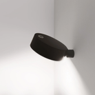 The black Super O Wall Spotlight Sconce from Zafferano in a studio.