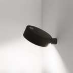 The black Super O Wall Spotlight Sconce from Zafferano in a studio.